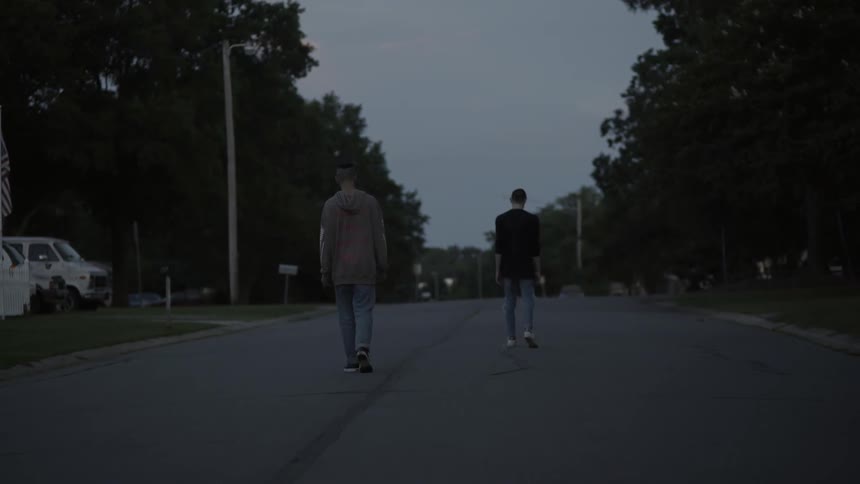 Two teenagers walking down the street on a cloudy day