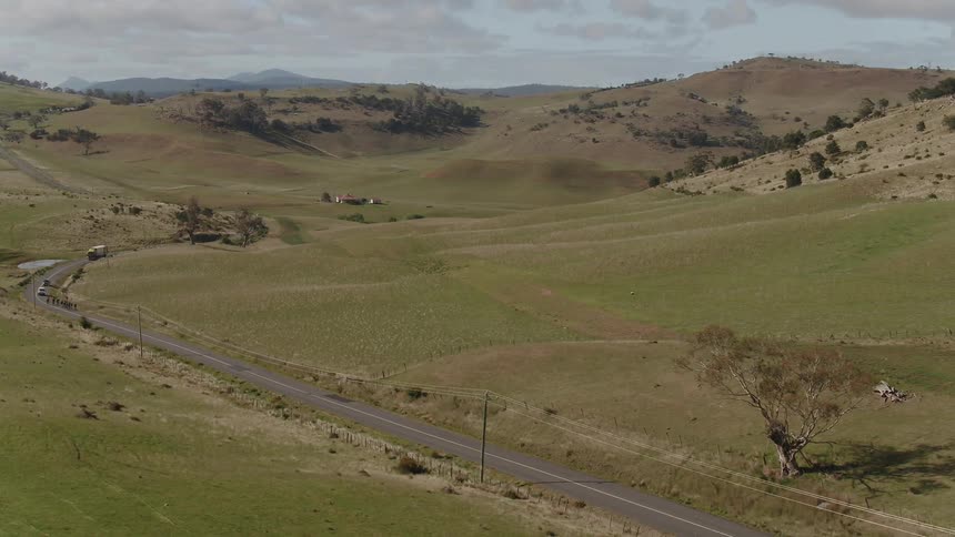 Line of vehicles moving down a winding road