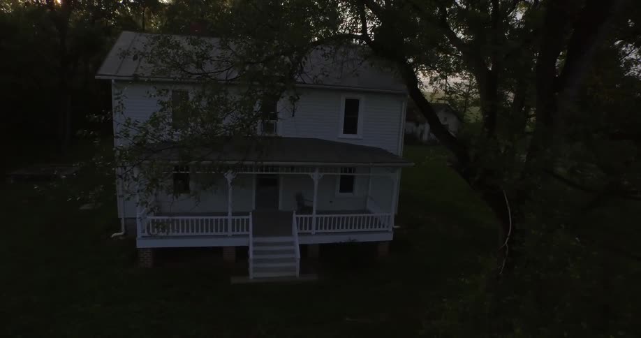 Two-story run down house sitting amongst the woods