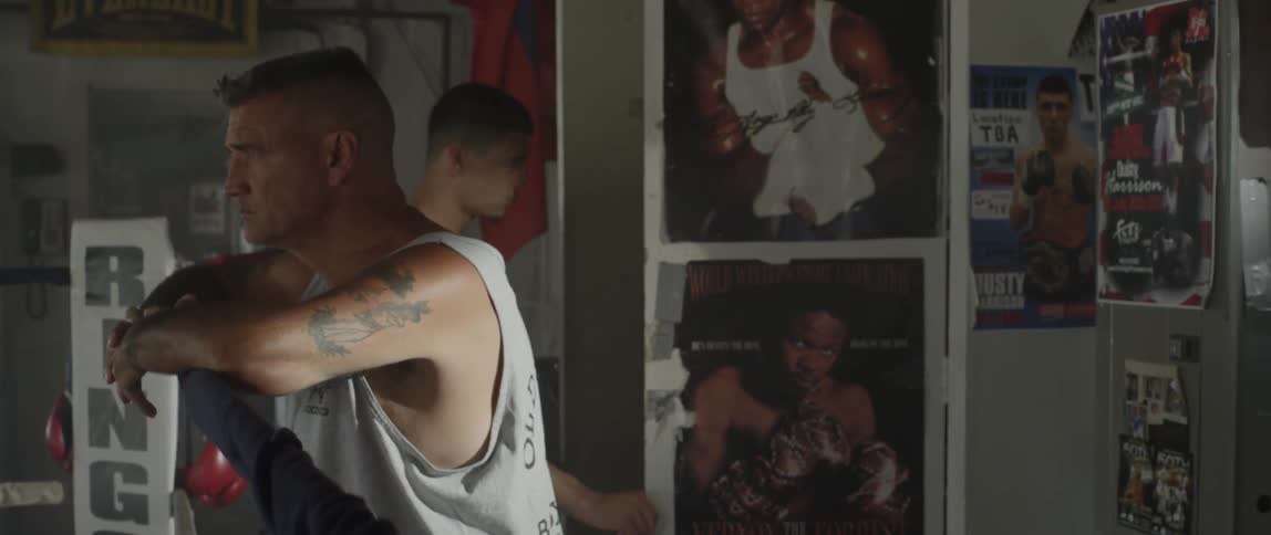 Two men inside of a gym talking