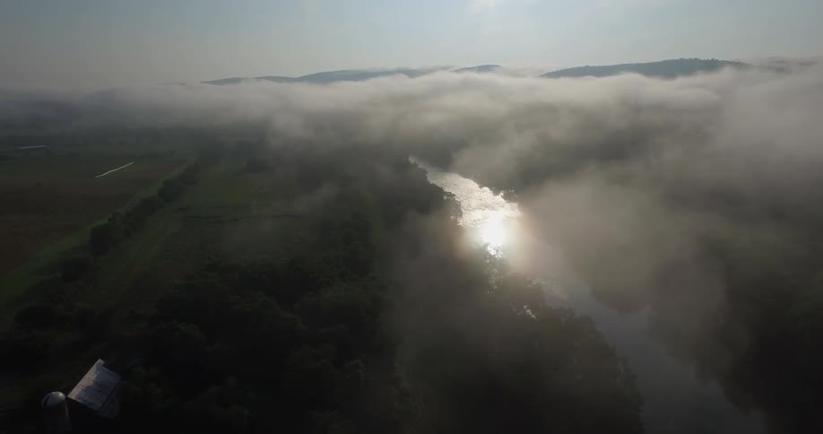 Dense clouds sit above a field separated by a narrow creek