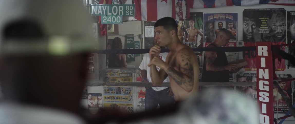 Man shadow boxes as others watch on