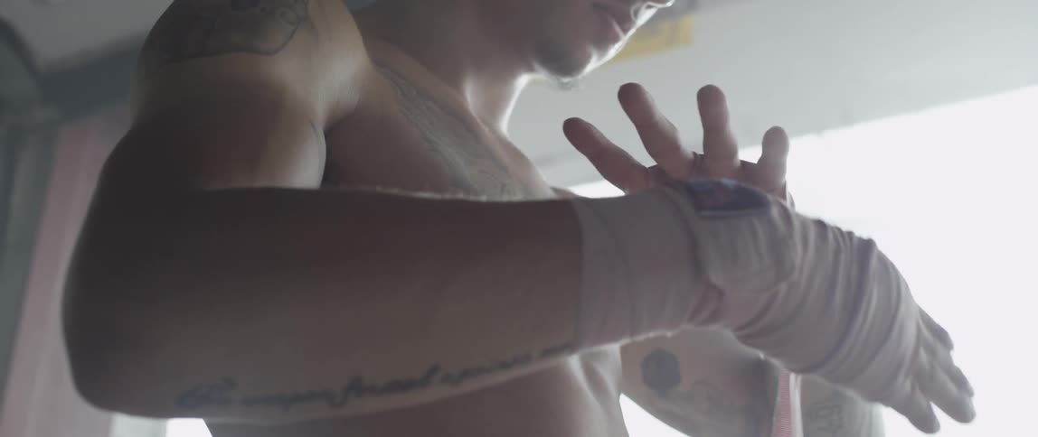 A boxer wraps his hands with athletic wrap