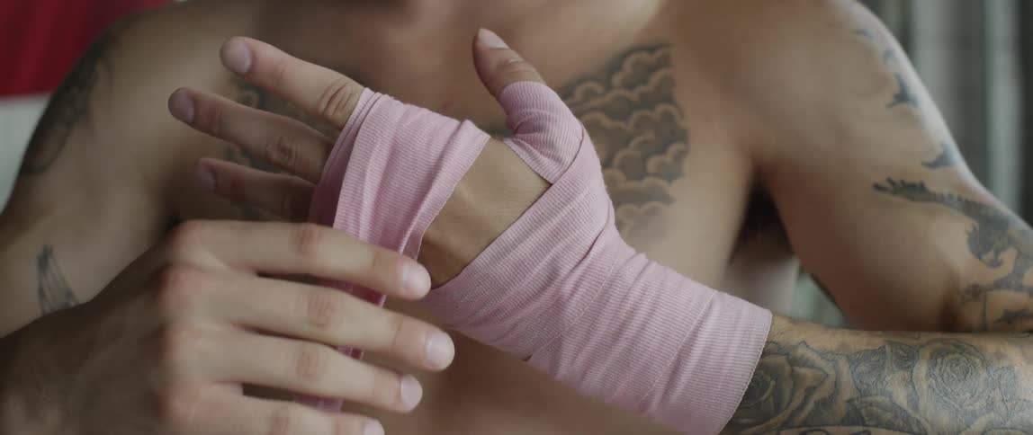 A man with no shirt is tapping up his hands