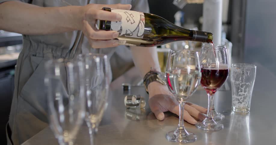 A person pours wine into a glass