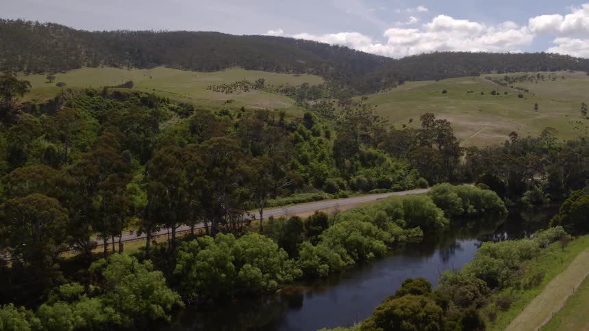 Vehicles on a road through hills and trees