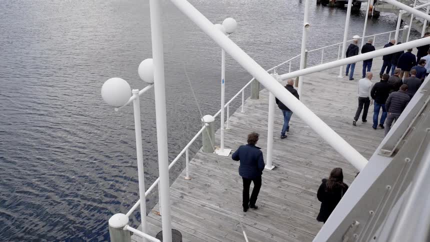 People walk on boardwalk near the water