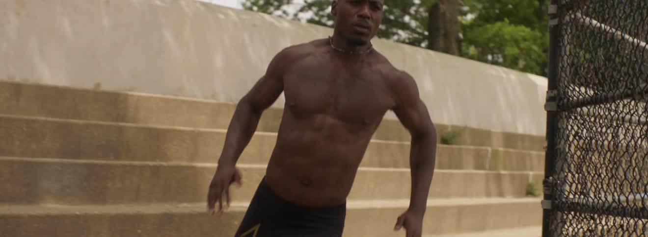 Shirtless man runs near cement steps