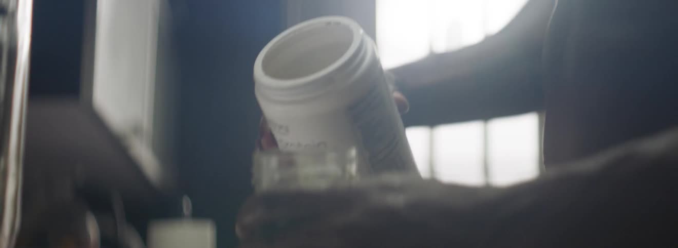 A man pour protein powder into a jar