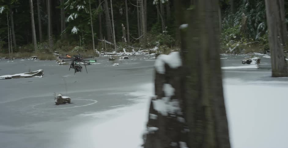 Drone flying through an open area in a forest