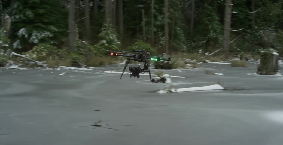 Drone flying through an open area in a forest