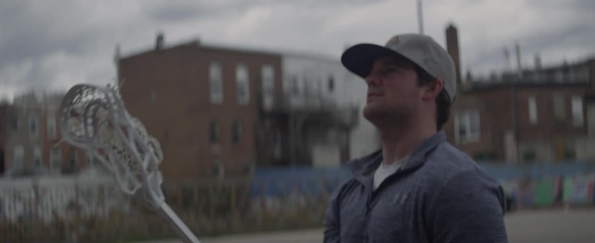 A man swings a lacrosse stick