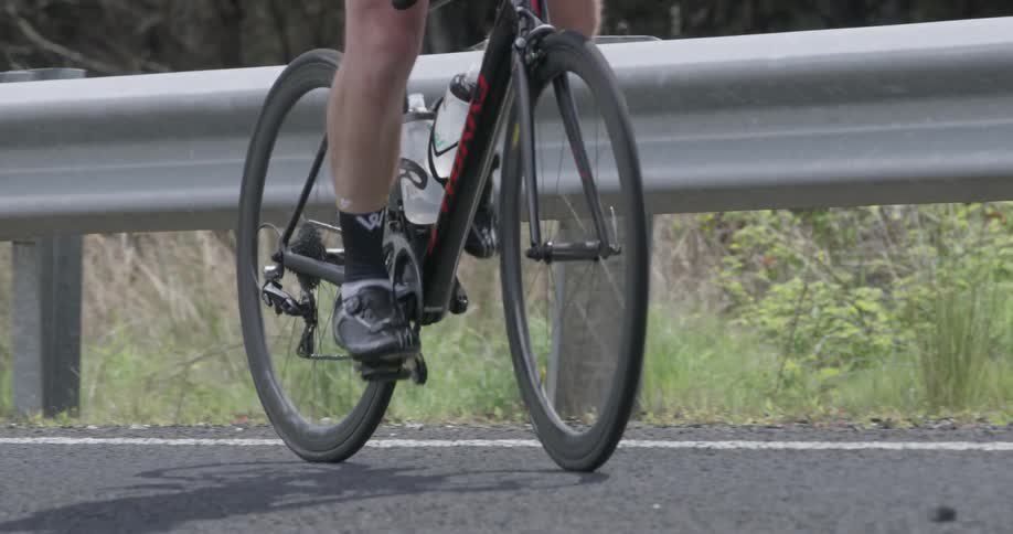 A person cycles across a bridge slowly