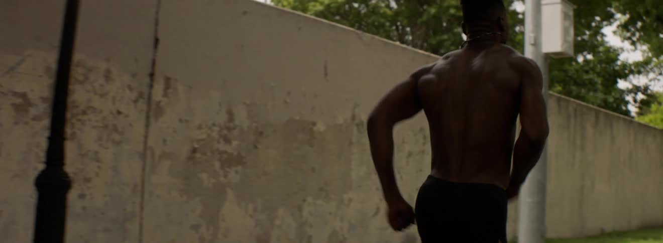 A male athlete sprints down an asphalt path