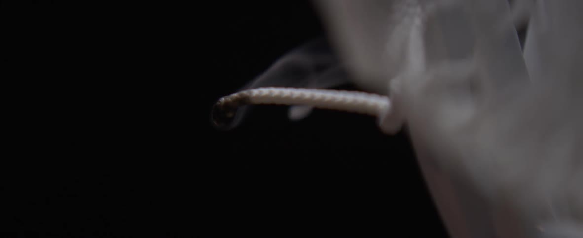 A flame burning on the end of a lace is blown out