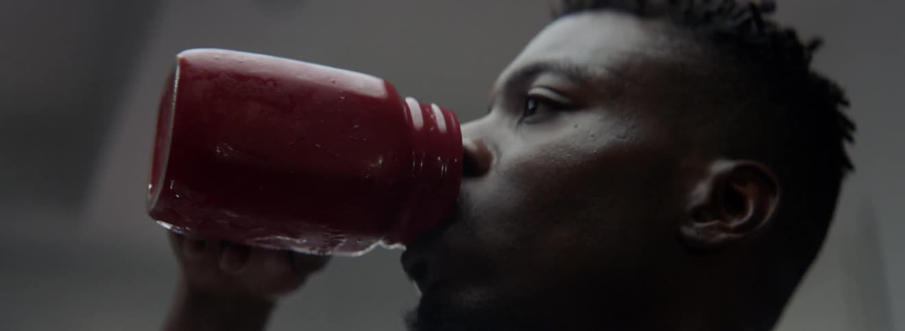 A man takes a long drink from a container