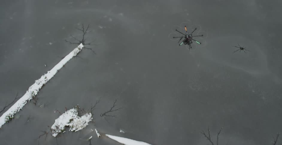 A drone flies high over a barren area
