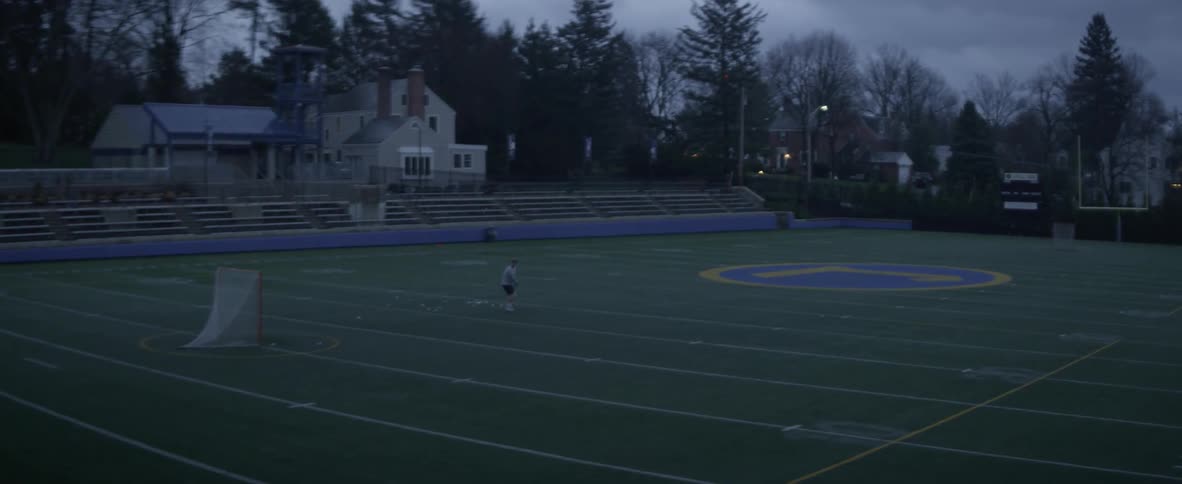 A person shoots the lacrosse ball into the net