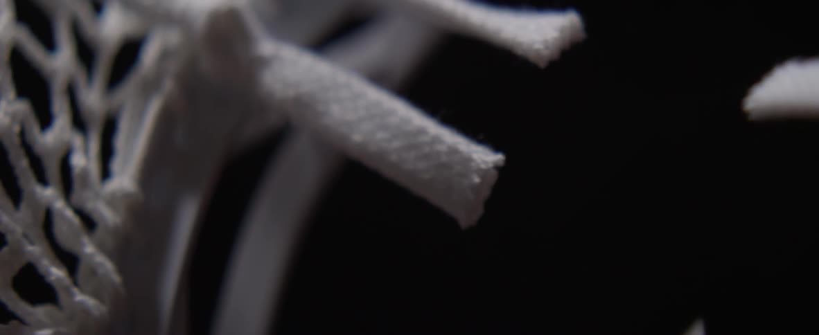 Two pieces of white twine is cut by scissors