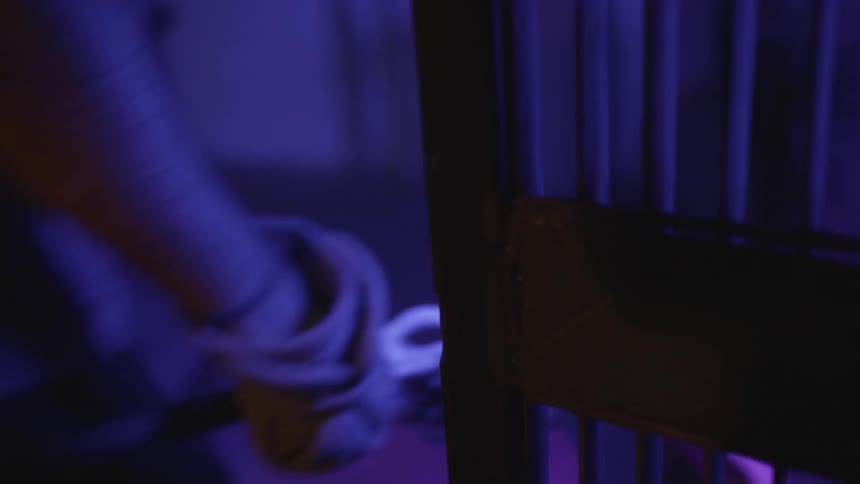 Person strikes a lock on a prison cell and walks out