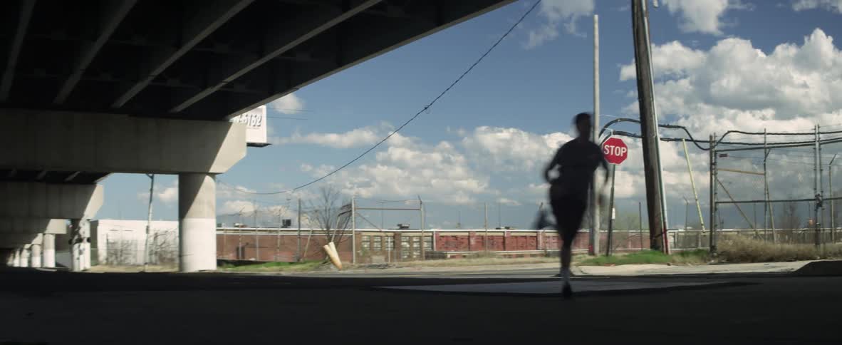 Man runs down the street and around a corner