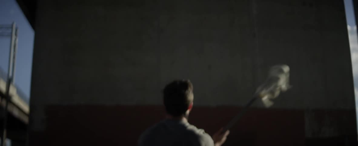 A man is throwing a ball against a wall
