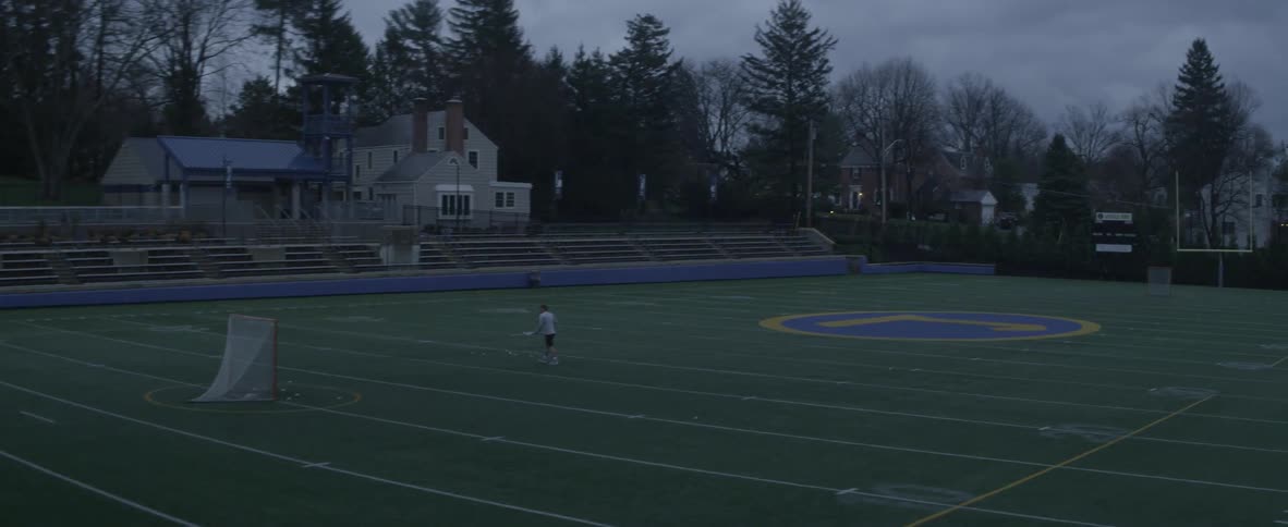 A man using a lacrosse stick practices taking shots