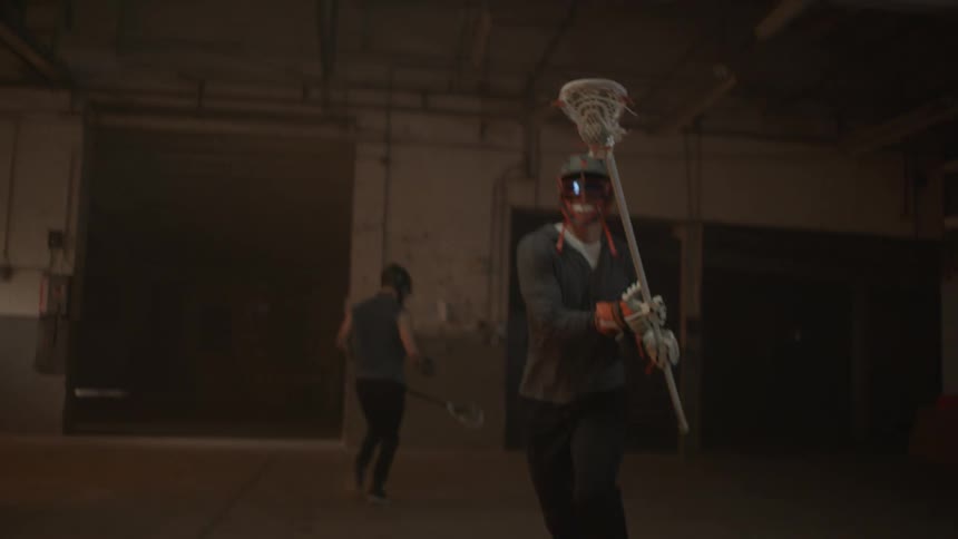 Lacrosse players face off swinging their sticks