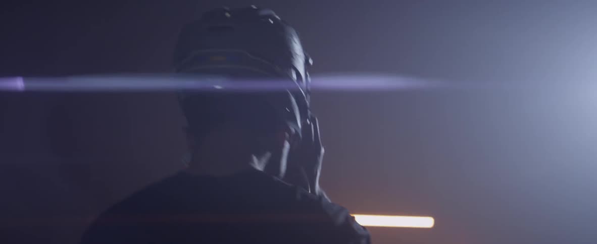 A man walks in the dark and puts on his helmet