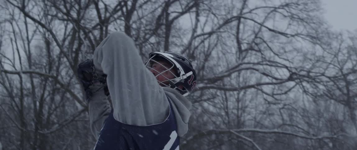A man plays lacrosse in the snow
