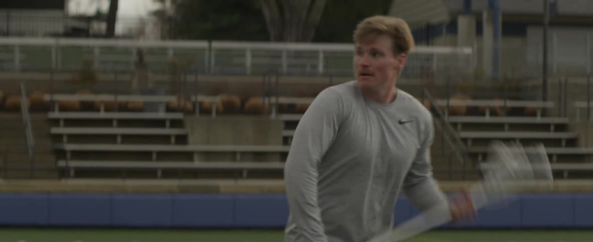 A man walks on the field and throws a ball