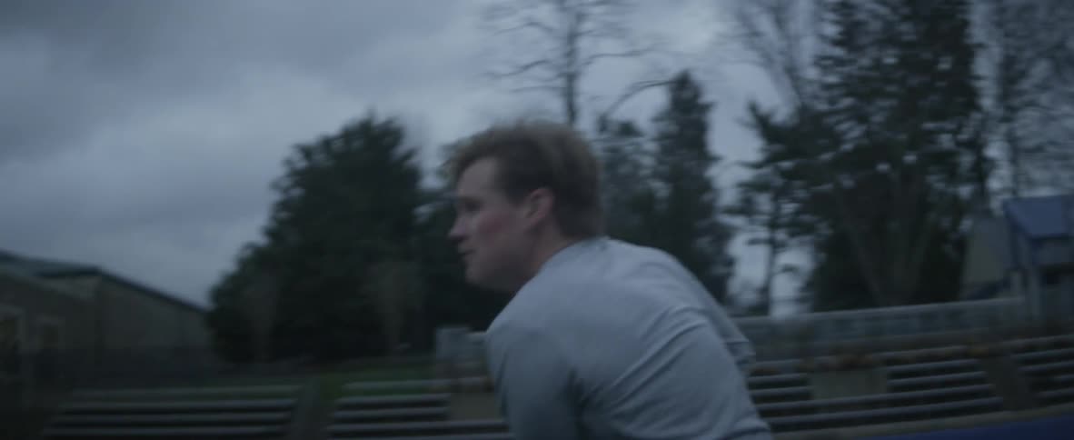 A man plays lacrosse alone on a sports field
