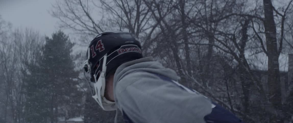 A man swings a stick in the snow