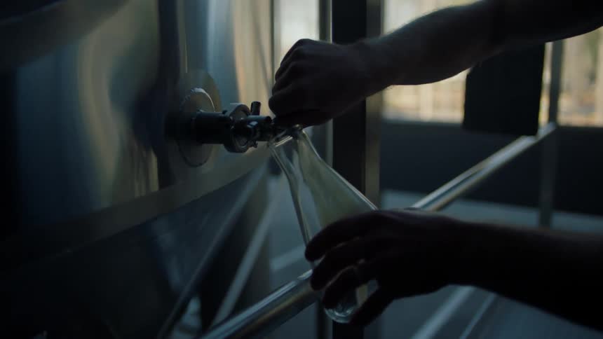 A man puts liquid into a beaker