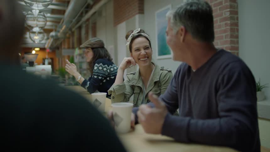 People talk and drink around a table