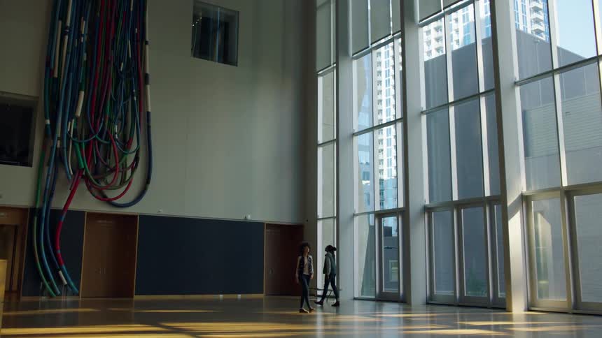 Two people walk past each other in the hall