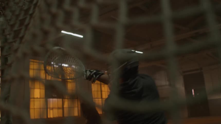 Lacrosse player shoots the ball past the goalie, into the net
