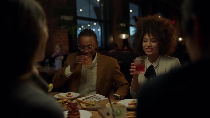 Many people are seated in a restaurant eating and drinking