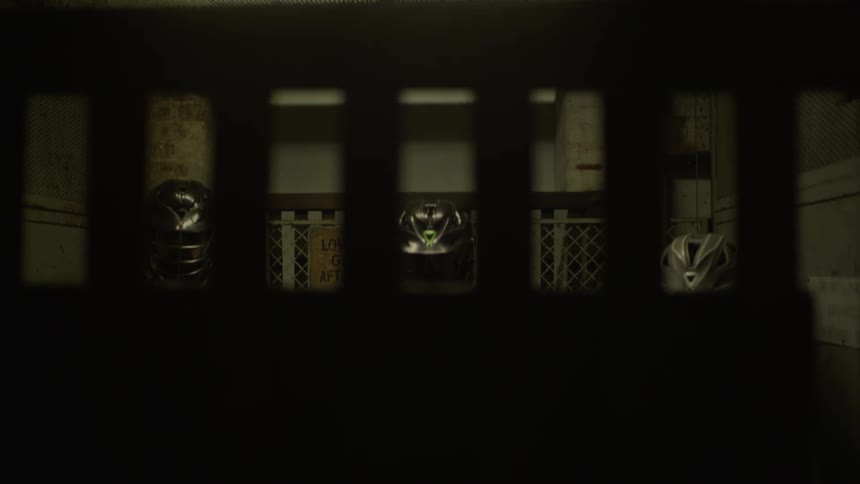 Three people in masks in a dark elevator that is going down