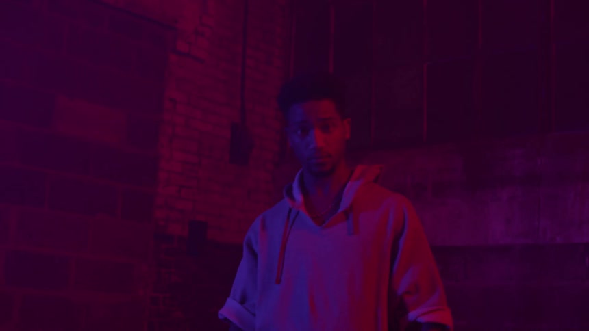 Man holding lacrosse gear in dark building