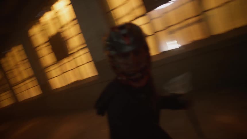 Lacrosse players race side by side in a dark gym