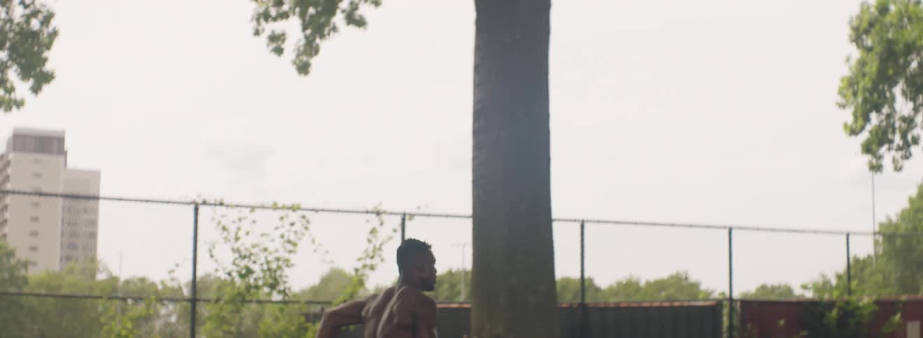 Man sprints down a street next to a park