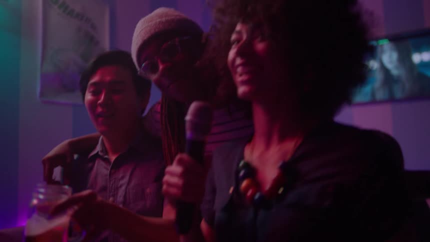 People singing karaoke together in a nightclub