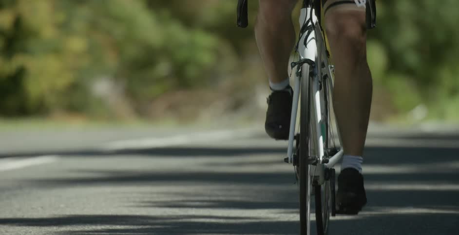 Cyclist wearing shorts travels down the road
