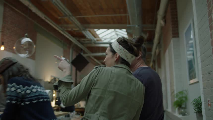 A man walks a young woman around an office