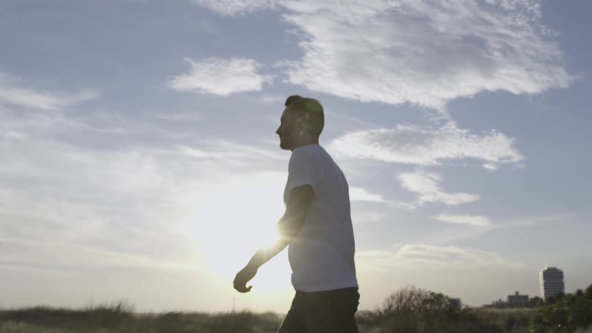 Man stands in a field at sunrise