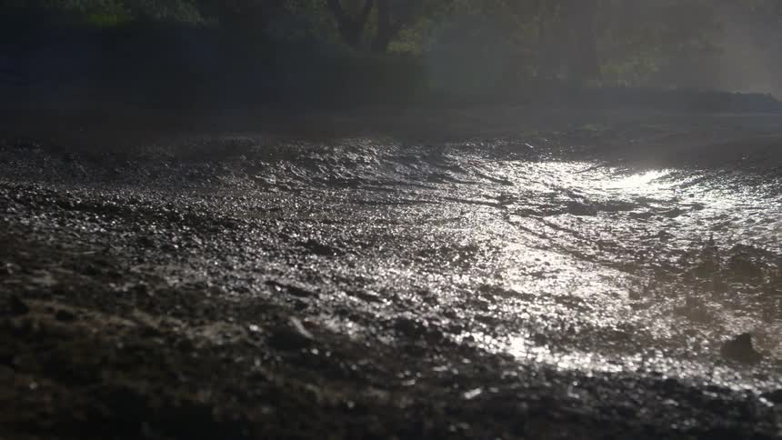 A person rides a bike through a mud puddle