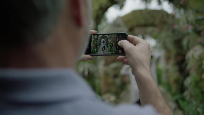 A man photographs a woman using his phone
