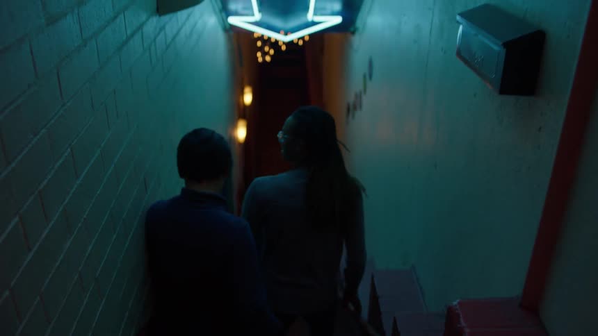A man and woman walk down a staircase