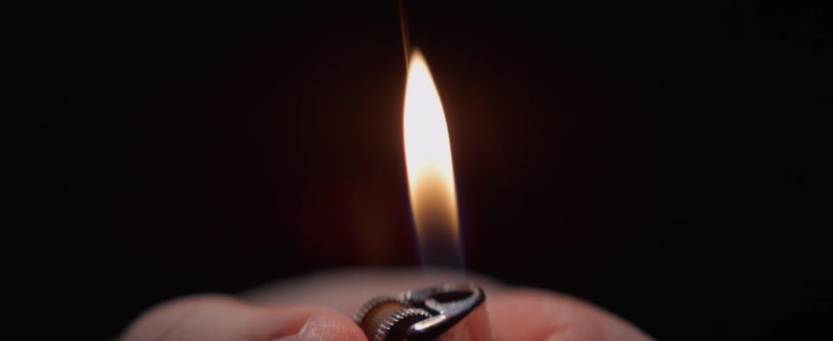 A person flicks a lighter on and off